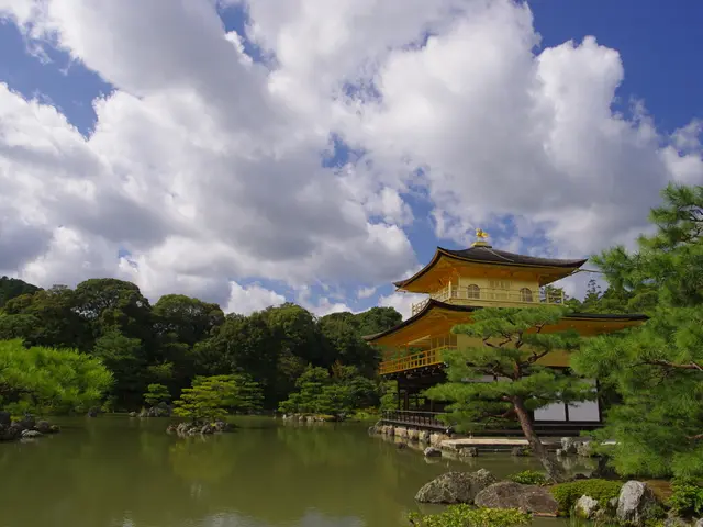In this image there is a lake in the background there are trees, a house and the sky.