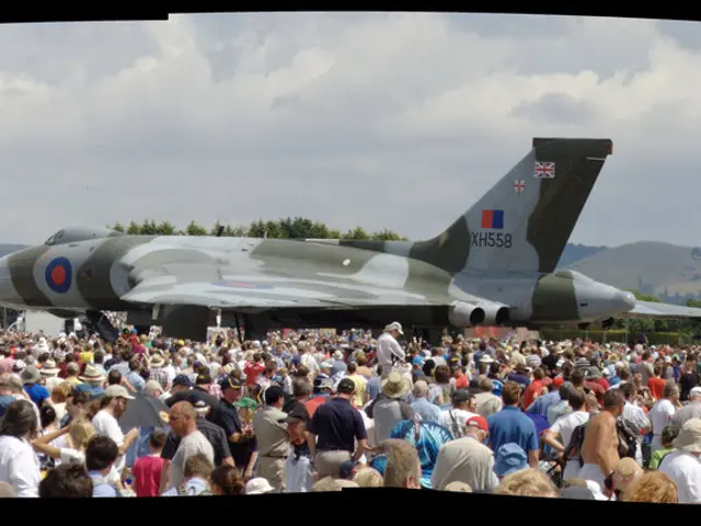 In this image in the center there is an airplane at the bottom there are a group of people, and in...