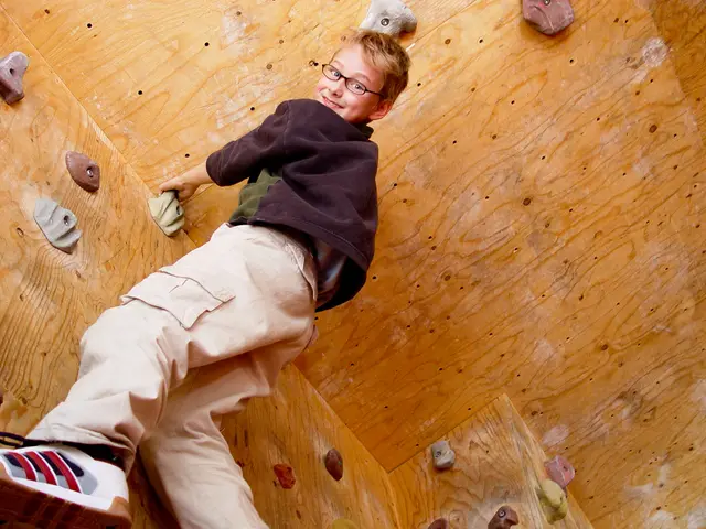 In this picture we can see a kid wearing a spectacle and smiling. This kid is performing indoor...